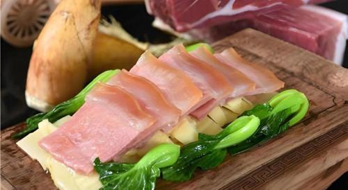 a plate of food with meat and vegetables on a cutting board at Huangshan International Hotel in Huangshan