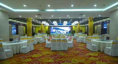 a banquet hall with white tables and white chairs at Huangshan International Hotel in Huangshan