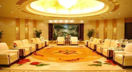 a large conference room with white chairs and a large painting at Huangshan International Hotel in Huangshan