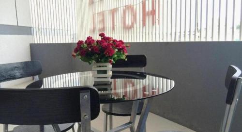 a table and chairs with a vase of flowers on it at Hotel D' CaLia Tarakan in Tarakan