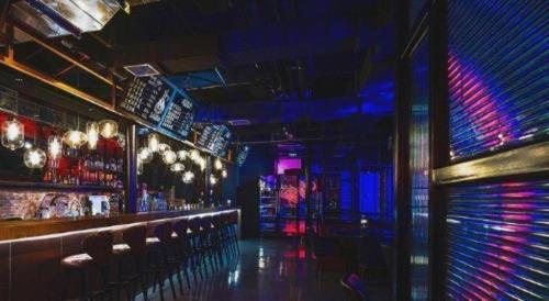 a bar with red and blue lights and chairs at NH Shijiazhuang Financial Center in Shijiazhuang