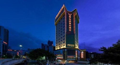 a tall building with lights on it at night at Out Sky Hotel in Huizhou
