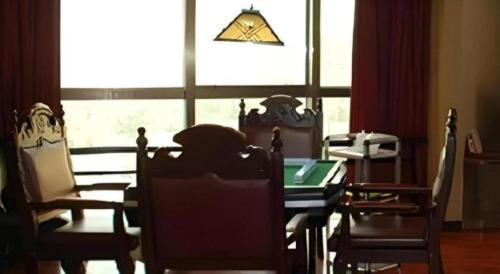 a dining room with a table and chairs and a window at Out Sky Hotel in Huizhou