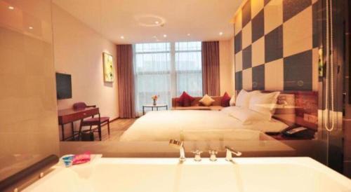 a hotel room with a bed and a bath tub at Hangzhou Berman Hotel in Hangzhou