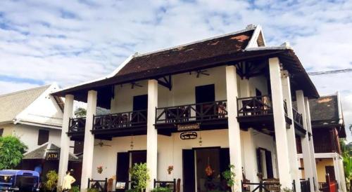 a white building with a balcony on top of it at The View Pavilion Hotel in Luang Prabang