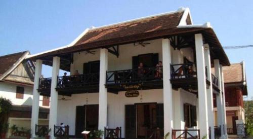 a large white building with people on the balcony at The View Pavilion Hotel in Luang Prabang