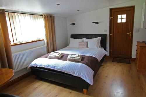 a bedroom with a bed with two towels on it at Sound of the River in Talgarth