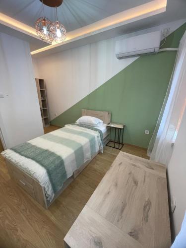 a bedroom with a bed with a green wall at Atila Apartment Ruse in Ruse