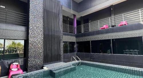 a swimming pool with a pink tub in a building at Nangfa Mini Hotel in Chiang Rai