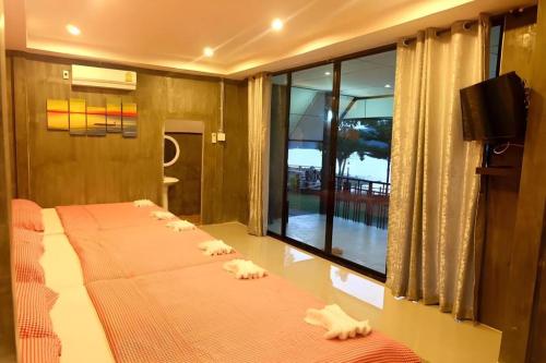 a bed in a room with a large window at Rim Kaeng resort in Phetchaburi