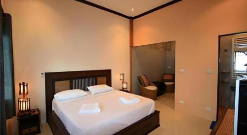 a bedroom with a large bed and a living room at Pilton Resort in Prachuap Khiri Khan