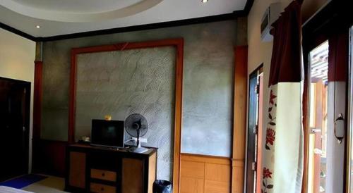 a room with a door with a mirror and a television at Pilton Resort in Prachuap Khiri Khan