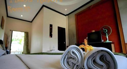 a bedroom with a bed with a white bedspread at Pilton Resort in Prachuap Khiri Khan