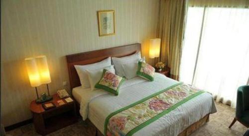 a hotel room with a large bed with two lamps at Labersa Grand Hotel &Convention Center in Pekanbaru
