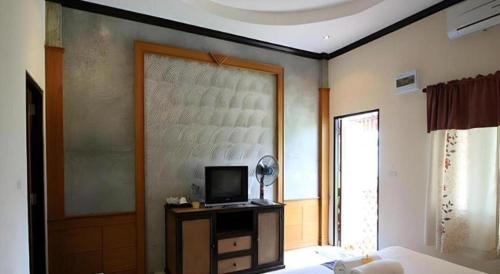 a bedroom with a bed and a television on a table at Pilton Resort in Prachuap Khiri Khan