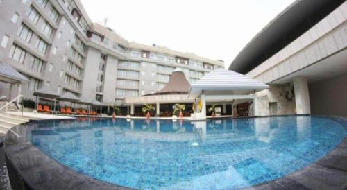 a large swimming pool in front of a building at Labersa Grand Hotel &Convention Center in Pekanbaru