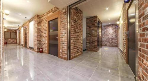 a room with brick walls and a hallway at H Hotel in Ulsan