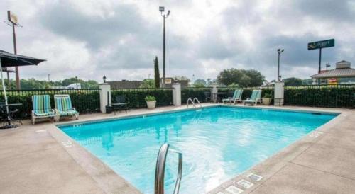 a large swimming pool with blue chairs at Quality Inn Prattville I-65 in Prattville