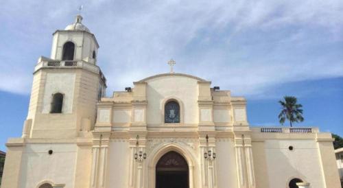 a large white church with a tower and a steeple at The Premiere Business Hotel in Kalibo