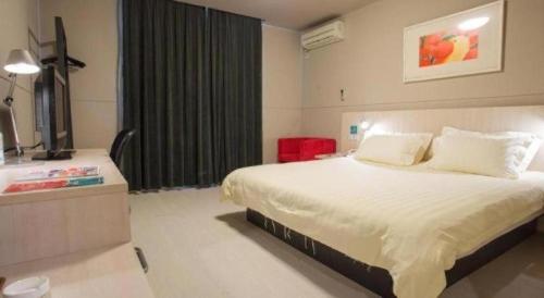 a hotel room with a bed and a television at Jinjiang Inn Wuhu Fangte Tech Museum Metro Station in Wuhu