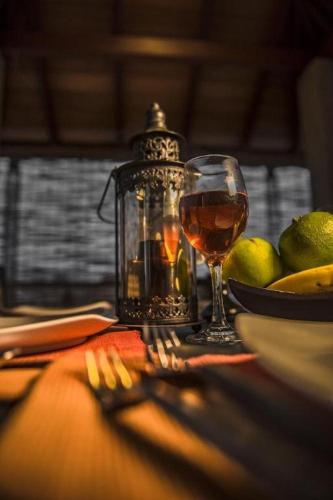 a table with a glass of wine and a plate of fruit at D Villas in Colombo