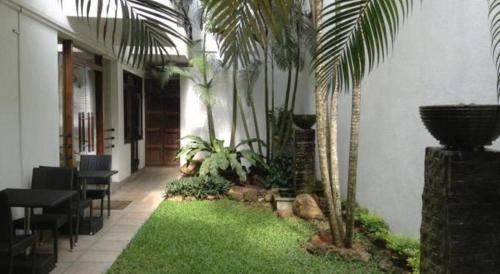 a courtyard with palm trees and a table and chairs at D Villas in Colombo