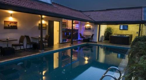 a swimming pool at night with a table and chairs at D Villas in Colombo