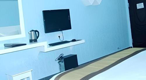 a living room with a tv and a bed with at Sheng Lin Na Hotel Minzhi Branch in Shenzhen