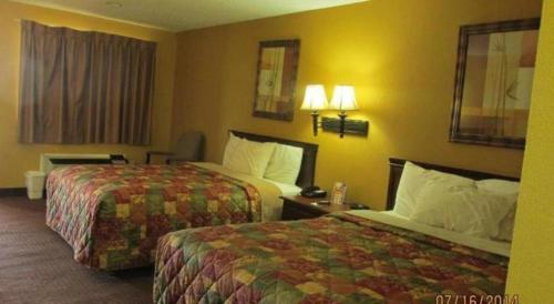 a hotel room with two beds and two lamps at Days Inn & Suites by Wyndham Byram in Byram