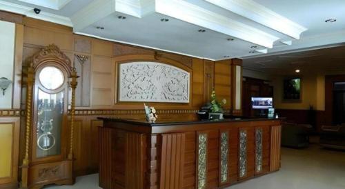 a lobby with a large wooden counter in a building at Larisae Setia Kawan Hotel in Solo