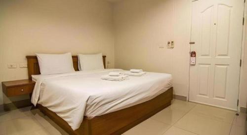 a bedroom with a large white bed with towels on it at At Home at Udon in Udon Thani