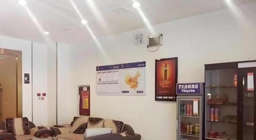 a living room with couches and a tv on a wall at 7 Days Inn Chengdu Huayang Metro Station Binfen Plaza in Chengdu