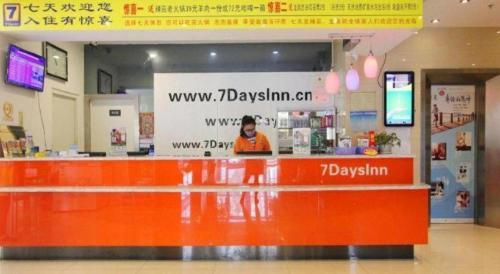 a person standing behind a counter in a store at 7 Days Inn Weihai High-Speed Railway & Bus Station in Weihai