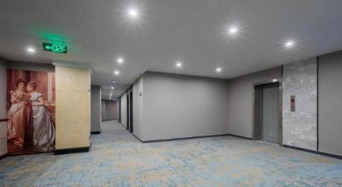 an empty room with a woman in a dress on the wall at 7 Days Inn Weihai High-Speed Railway & Bus Station in Weihai