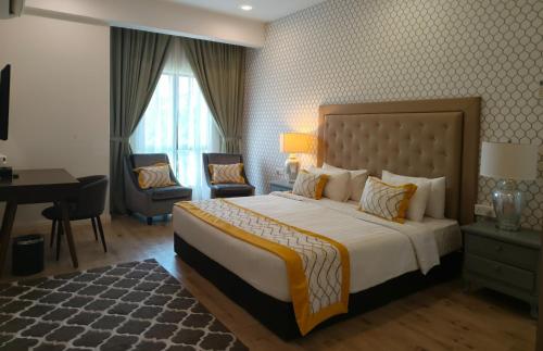 a hotel room with a large bed and a desk at RPGC Garden Hotel in Ipoh