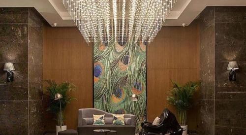 a room with a chandelier and a chair and a painting at ibis Styles Wuhan Optics Valley Square Hotel in Wuhan