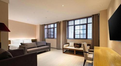 a living room with a couch and a bed and a tv at ibis Styles Wuhan Optics Valley Square Hotel in Wuhan