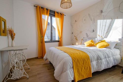 a bedroom with a large bed with yellow pillows at Le clos suzette in Bouranton