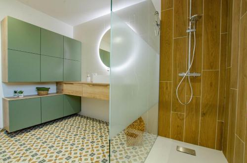 a bathroom with green cabinets and a shower at Le clos suzette in Bouranton