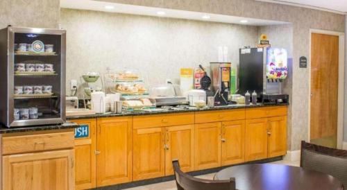 a kitchen with wooden cabinets and a counter top at Econo Lodge Raleigh near Walnut Creek Amphitheatre in Raleigh