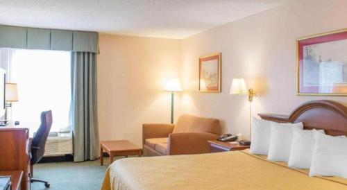 a hotel room with a bed and a living room at Econo Lodge Raleigh near Walnut Creek Amphitheatre in Raleigh