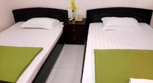 two beds sitting next to each other in a room at Quang Sang Hotel Can Tho in Can Tho