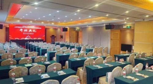 a conference hall with blue tables and chairs and a screen at Vienna International Shenzhen Tianan Digital City in Shenzhen