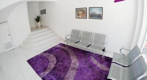 a room with a bench and a purple rug at Hotel Zing Phnom Penh in Phnom Penh