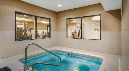 a swimming pool in a room with two windows at Quality Inn & Suites Jefferson City in Jefferson City