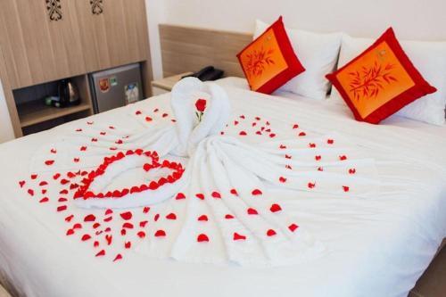 a white bed with red hearts on it at Green Hotel Da Nang in Da Nang