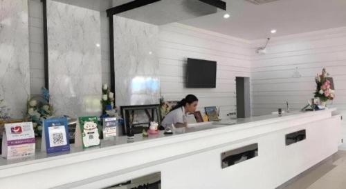 a woman is sitting at a counter in a store at Thanburi Hotel in Udon Thani