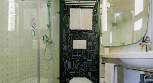 a bathroom with a shower and a sink and a mirror at ibis xian North Second Ring Weiyang Rd Hotel in Xi'an