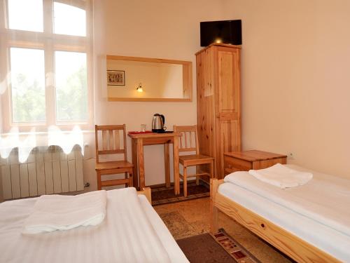 1 dormitorio con 2 camas, mesa y sillas en Villa Dom Julii, en Sanok
