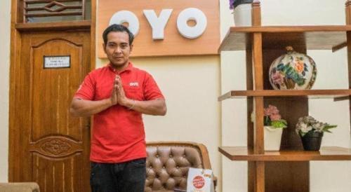 a man in a red shirt standing in a room at OYO 643 Al Thalib 8 Syariah in Malang